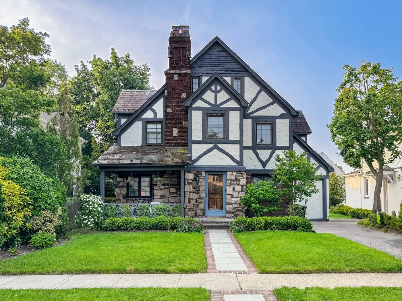 Tudor-style home with a stone and timber front and a green front lawn